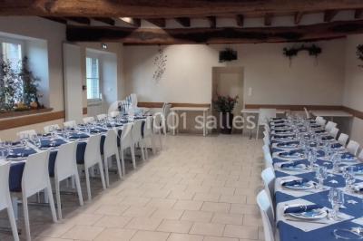 Bouteilles de jus de pomme, pot de confiture et noix disposés sur une nappe rouge à pois, avec un plat vert en arrière-plan.