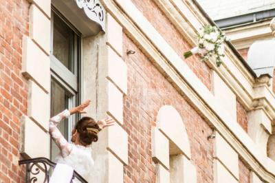 Façade d'un château éclairé au crépuscule, vue depuis un parterre de fleurs au premier plan.