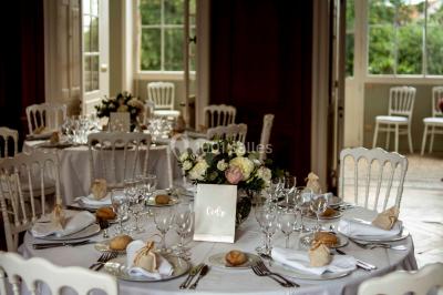 Façade d'un château éclairé au crépuscule, vue depuis un parterre de fleurs au premier plan.
