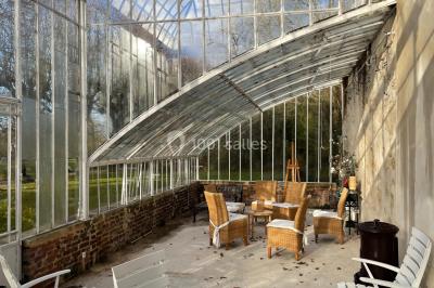 Façade d'un château éclairé au crépuscule, vue depuis un parterre de fleurs au premier plan.