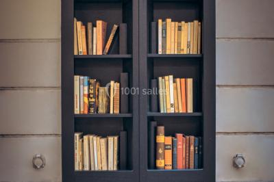 Bibliothèque intégrée dans une façade, remplie de livres aux couvertures variées, dans un cadre urbain.