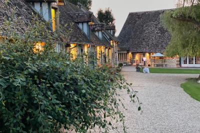 Platines vinyles et disques exposés sur une table en extérieur, avec un jardin verdoyant et un pigeonnier à colombages en…