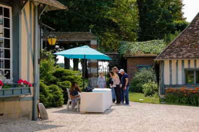 Platines vinyles et disques exposés sur une table en extérieur, avec un jardin verdoyant et un pigeonnier à colombages en…