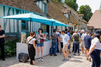 Platines vinyles et disques exposés sur une table en extérieur, avec un jardin verdoyant et un pigeonnier à colombages en…