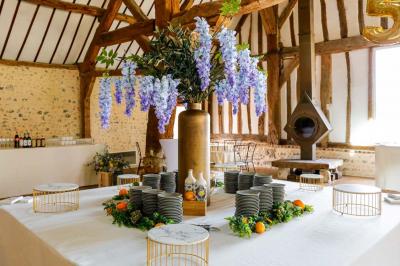 Platines vinyles et disques exposés sur une table en extérieur, avec un jardin verdoyant et un pigeonnier à colombages en…