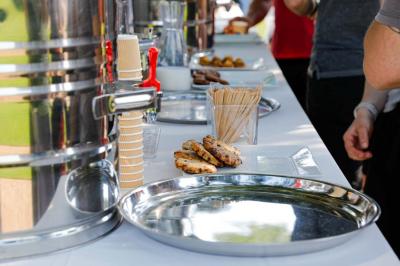 Platines vinyles et disques exposés sur une table en extérieur, avec un jardin verdoyant et un pigeonnier à colombages en…