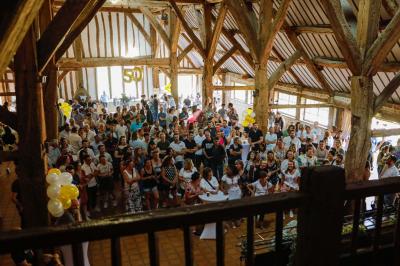 Platines vinyles et disques exposés sur une table en extérieur, avec un jardin verdoyant et un pigeonnier à colombages en…