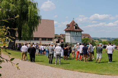 Platines vinyles et disques exposés sur une table en extérieur, avec un jardin verdoyant et un pigeonnier à colombages en…