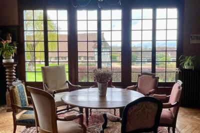 Platines vinyles et disques exposés sur une table en extérieur, avec un jardin verdoyant et un pigeonnier à colombages en…