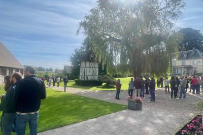 Platines vinyles et disques exposés sur une table en extérieur, avec un jardin verdoyant et un pigeonnier à colombages en…