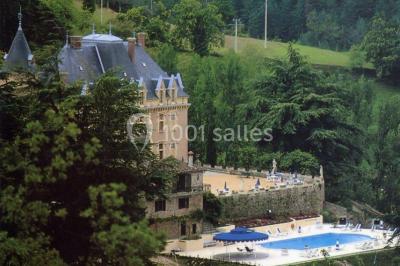 Des personnes en tenue traditionnelle dansent et célèbrent en extérieur, devant des bâtiments en pierre et végétation.