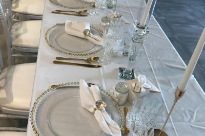 Des personnes en tenue traditionnelle dansent et célèbrent en extérieur, devant des bâtiments en pierre et végétation.