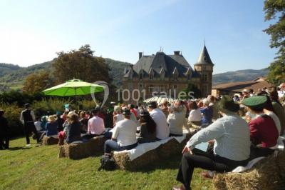 Façade d'un bâtiment ancien avec des arches vitrées, entouré de végétation et d'un escalier sur la gauche.