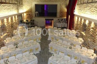 Façade d'un bâtiment ancien avec des arches vitrées, entouré de végétation et d'un escalier sur la gauche.