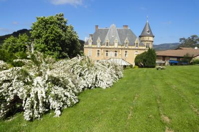 Façade d'un bâtiment ancien avec des arches vitrées, entouré de végétation et d'un escalier sur la gauche.