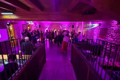 Façade d'un bâtiment ancien avec des arches vitrées, entouré de végétation et d'un escalier sur la gauche.