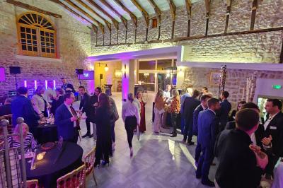 Façade d'un bâtiment ancien avec des arches vitrées, entouré de végétation et d'un escalier sur la gauche.