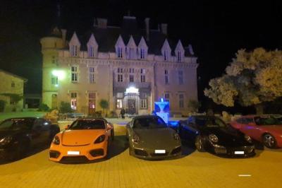 Façade d'un bâtiment ancien avec des arches vitrées, entouré de végétation et d'un escalier sur la gauche.