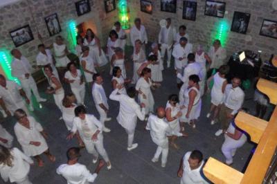 Façade d'un bâtiment ancien avec des arches vitrées, entouré de végétation et d'un escalier sur la gauche.