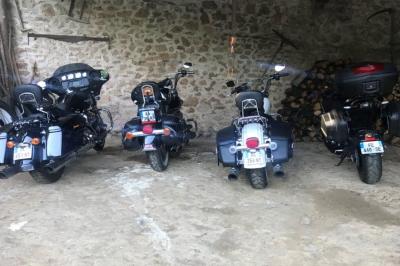 Façade d'un bâtiment ancien avec des arches vitrées, entouré de végétation et d'un escalier sur la gauche.