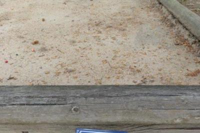 Façade d'un bâtiment ancien avec des arches vitrées, entouré de végétation et d'un escalier sur la gauche.