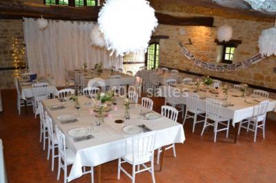 Groupe de personnes rassemblées en extérieur sous des arbres, discutant près de tables et de chaises.
