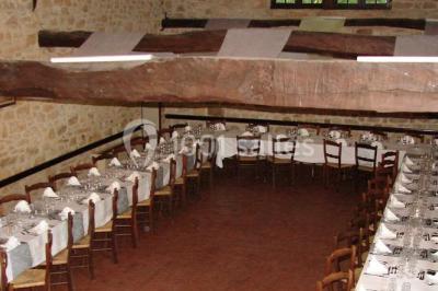 Groupe de personnes rassemblées en extérieur sous des arbres, discutant près de tables et de chaises.