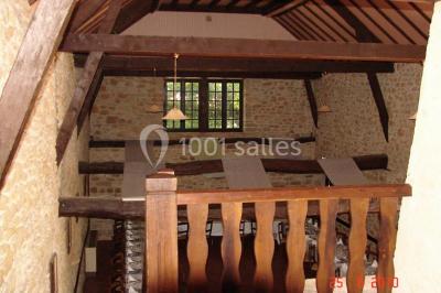 Groupe de personnes rassemblées en extérieur sous des arbres, discutant près de tables et de chaises.