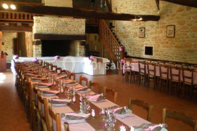 Groupe de personnes rassemblées en extérieur sous des arbres, discutant près de tables et de chaises.