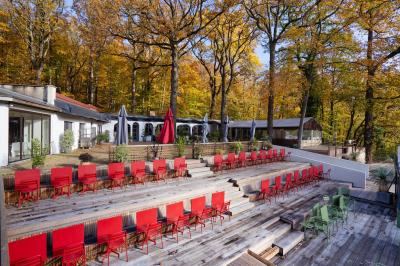 Outils en métal pour cheminée rangés dans un support cylindrique devant un pare-feu en métal.