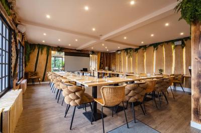 Outils en métal pour cheminée rangés dans un support cylindrique devant un pare-feu en métal.