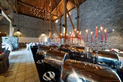 Miniature Location salle Modave (Liège) - Domaine du Château de Modave #9 Mobilier de jardin en rotin sur une pelouse avec un château en pierre en arrière-plan et une structure gonflable colorée.