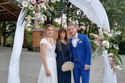 Salle en bois avec des bancs alignés sur un sol en gazon synthétique, décorée de fleurs suspendues.