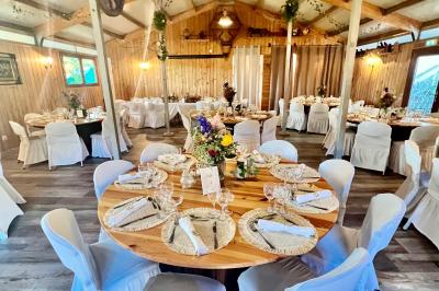 Salle en bois avec des bancs alignés sur un sol en gazon synthétique, décorée de fleurs suspendues.