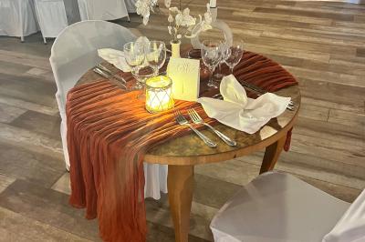 Salle en bois avec des bancs alignés sur un sol en gazon synthétique, décorée de fleurs suspendues.