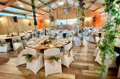 Salle en bois avec des bancs alignés sur un sol en gazon synthétique, décorée de fleurs suspendues.
