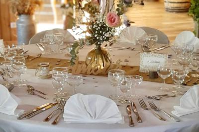 Salle en bois avec des bancs alignés sur un sol en gazon synthétique, décorée de fleurs suspendues.