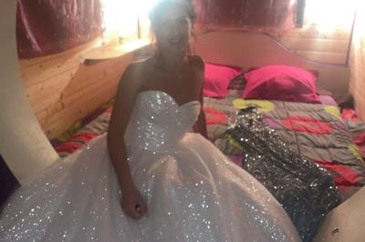 Salle en bois avec des bancs alignés sur un sol en gazon synthétique, décorée de fleurs suspendues.