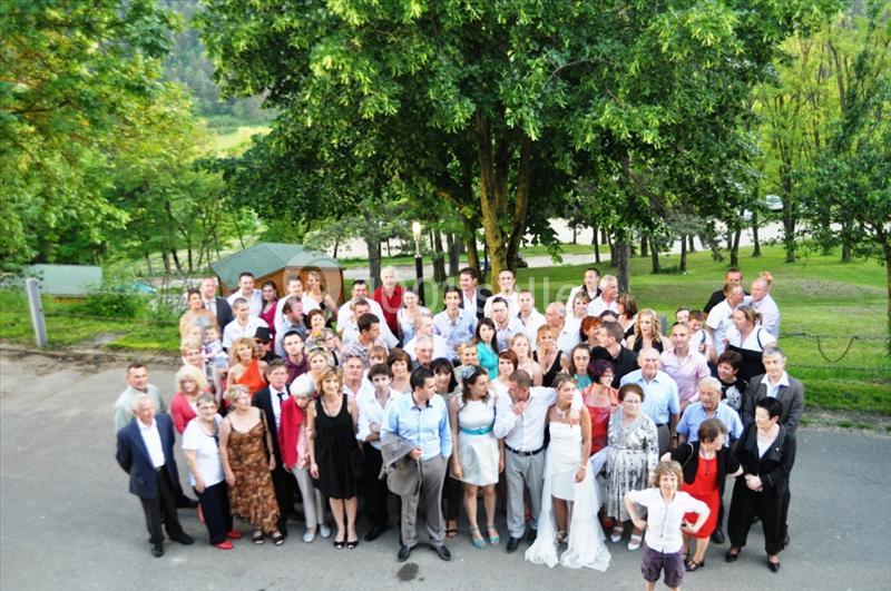 Un grand groupe de personnes posant à l'extérieur dans un cadre verdoyant avec des arbres en arrière-plan.