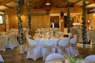 Salle en bois avec des bancs alignés sur un sol en gazon synthétique, décorée de fleurs suspendues.