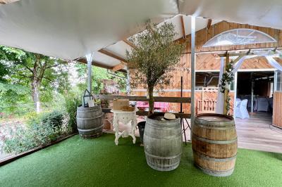 Salle en bois avec des bancs alignés sur un sol en gazon synthétique, décorée de fleurs suspendues.