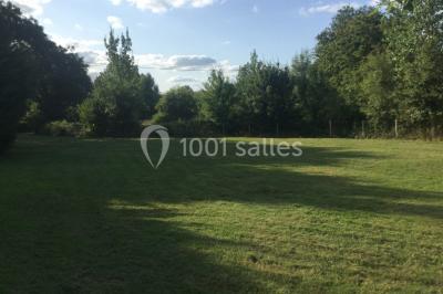 Salle décorée avec des tables hautes blanches, des nappes et des éléments suspendus dans un style épuré et chaleureux.