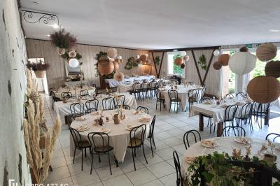 Salle décorée avec des tables hautes blanches, des nappes et des éléments suspendus dans un style épuré et chaleureux.