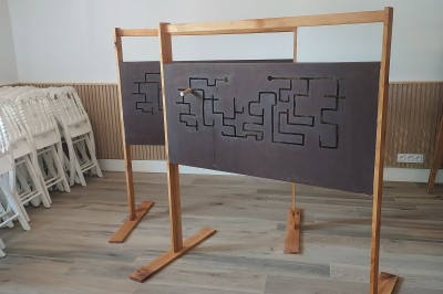 Salle de réception avec une table ronde décorée, des ballons et une grande table dressée en arrière-plan.