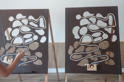 Salle de réception avec une table ronde décorée, des ballons et une grande table dressée en arrière-plan.