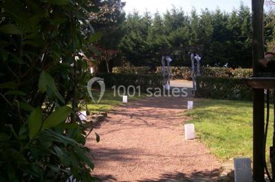 Salle décorée avec des tables hautes blanches, des nappes et des éléments suspendus dans un style épuré et chaleureux.