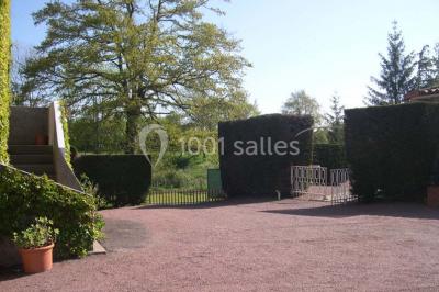 Salle décorée avec des tables hautes blanches, des nappes et des éléments suspendus dans un style épuré et chaleureux.
