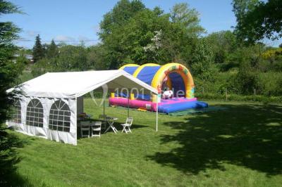 Salle décorée avec des tables hautes blanches, des nappes et des éléments suspendus dans un style épuré et chaleureux.