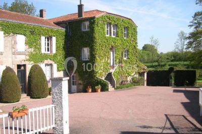 Salle décorée avec des tables hautes blanches, des nappes et des éléments suspendus dans un style épuré et chaleureux.