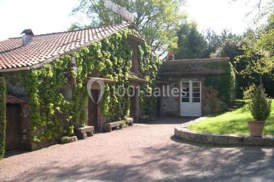 Salle décorée avec des tables hautes blanches, des nappes et des éléments suspendus dans un style épuré et chaleureux.